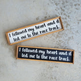 Wood racing themed sign that says I followed my heart and it led me to the race track.