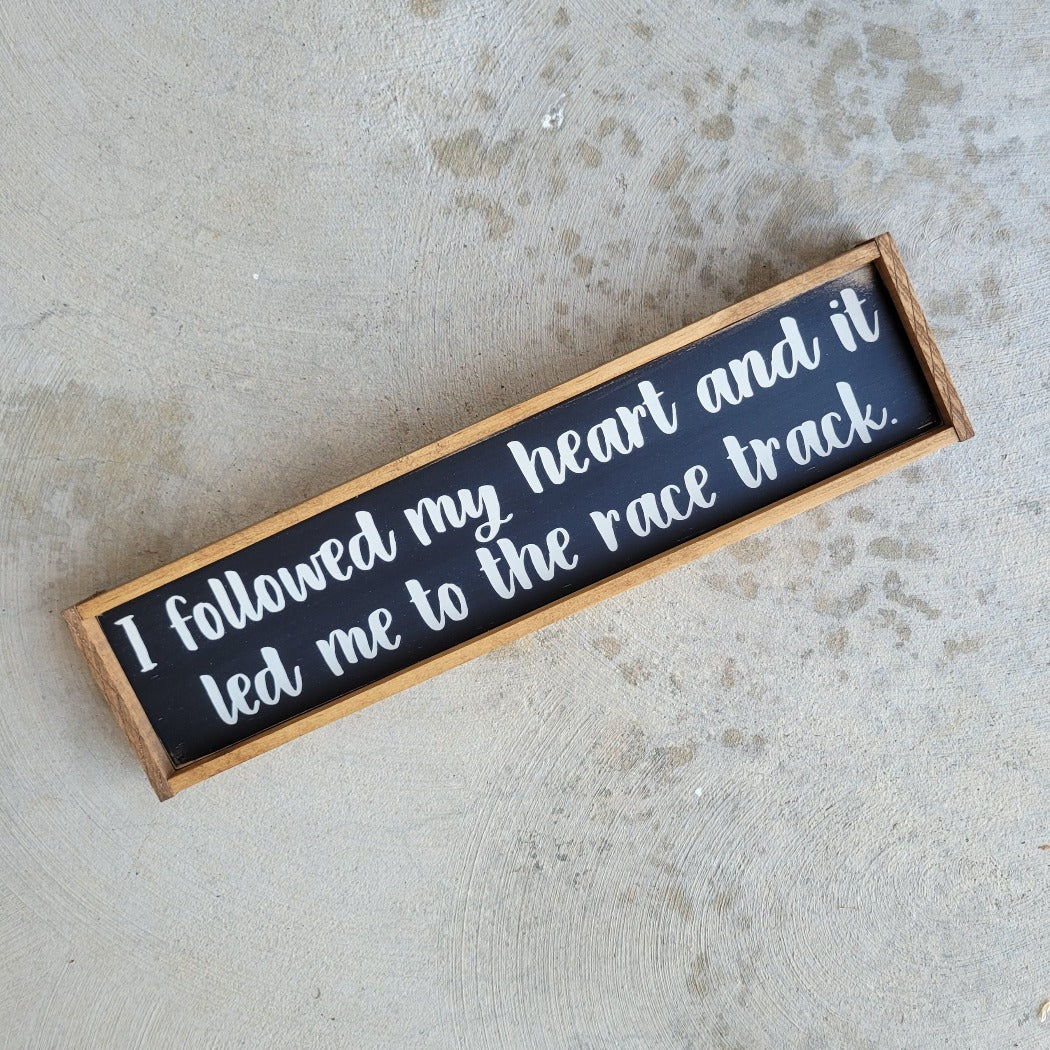 Wood racing themed sign that says I followed my heart and it led me to the race track.