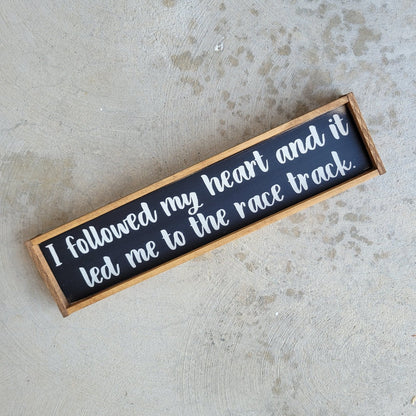Wood racing themed sign that says I followed my heart and it led me to the race track.