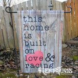 Racing garden flag, wood background. This home is built on love & racing.