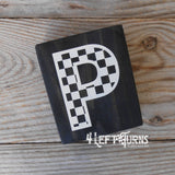 Block of wood with painted on checkered letter P.
