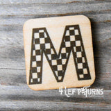 Checkered letter M wooden magnet.